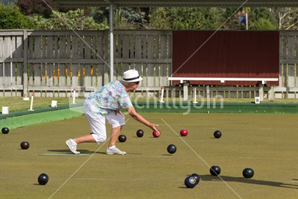 Woman bowling in game of lawn bowls. 