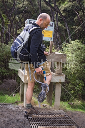 Man spraying boots to control Kauri Dieback