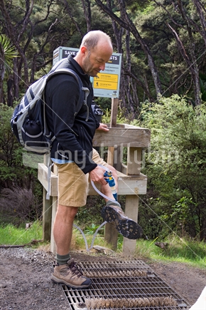 Man spraying boots to control Kauri Dieback
