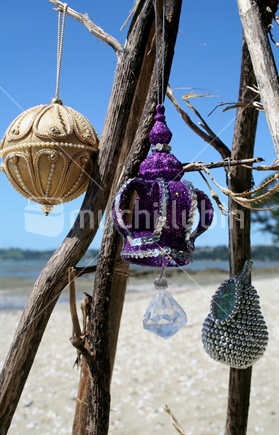 Christmas decorations hang from flax branches