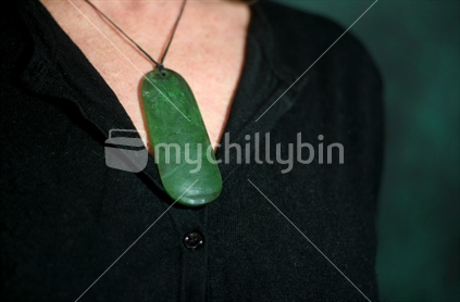 Head and shoulders shot of woman wearing pounamu (NZ greenstone)