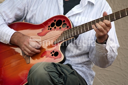 Man strumming an acoustic guitar