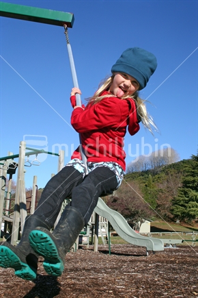 School aged girl playing on a swing
