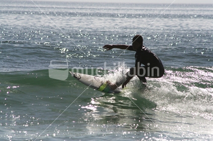Young man surfing a right hander, northland beach