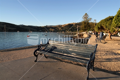 Park bench at the waterfront of Akaroa harbour, New Zealand