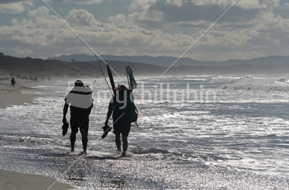 Fishermen walking down the beach, New Zealand