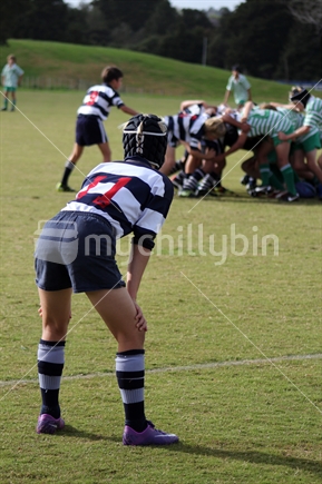 Number 11 waits outside the scrum, junior rugby game. 