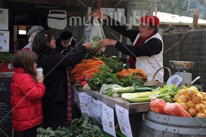 A woman buys vegetables at the Matakana Farmers market. 