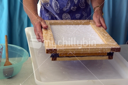 Making hand-made paper with pulp and deckle.