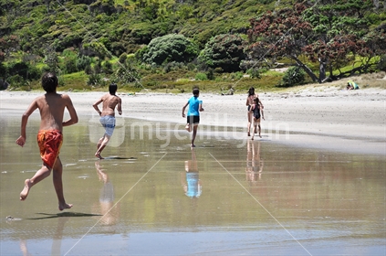 Kids run on a remote beach