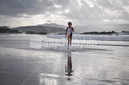 Girl swims on a stormy day (selective focus and some motion blur)