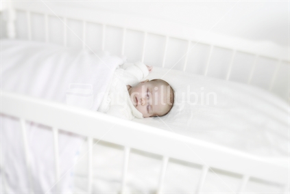 Baby sleeping in a cot (selective focus)