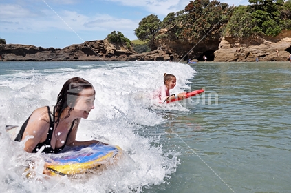 Mum and daughter boogie board together (selective focus and some motion blur)