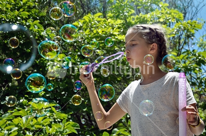 Girl blows bubbles in the bush (selective focus and some motion blur) see also Image #100468_350