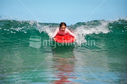 Happy girl on a boogie board (selective focus and some motion blur)