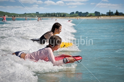 Mum and daughter boogie board together (selective focus and some motion blur) 