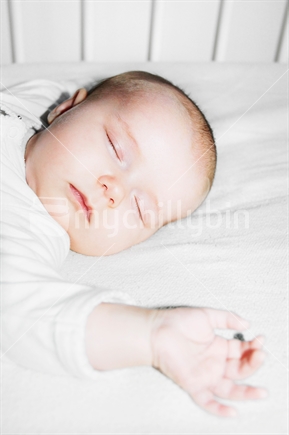 Baby asleep in a cot (selective focus)