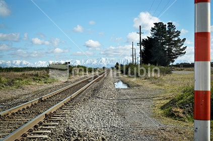 Railway crossing on the Canterbury Plains, with the Southern Alps in the background.