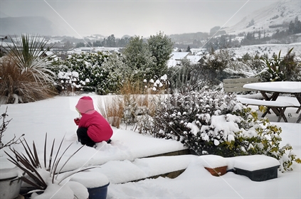 A child plays in a winter garden