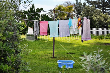 Tea towels hanging on a rotary washing line in a New Zealand backyard