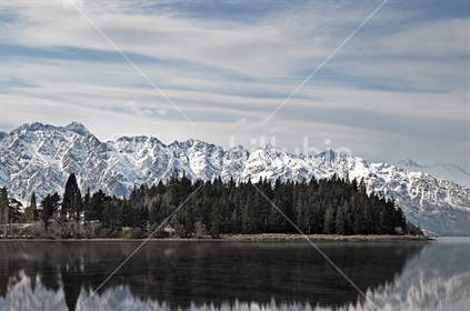 The Remarkables reflected in Lake Wakatipu, viewed from Queenstown, South Island, New Zealand.