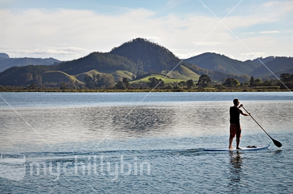 A lone stand up paddleboarder, Opoutere estuary, Coromandel, North Island, New Zealand.