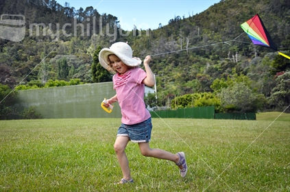 A happy young girl trying to fly a kite (motion blur)