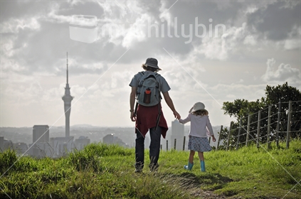 Father and daughter go for a walk across the farm on Mount Hobson volcanic cone, Remuera, Auckland.