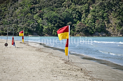 Surf patrol flags flutter on an empty beach