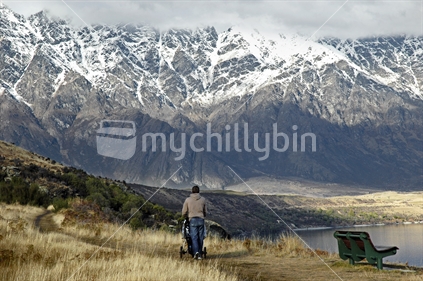 A walk along the shore of Lake Wakatipu looking toward The Remarkables near Queenstown. South Island, New Zealand
