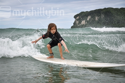 Young girl learning to surf (selective focus and some motion blur)