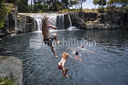 Family jumping at Charlie's Rock waterfall near Kerikeri, Northland (selective focus and some motion blur) See also #100468_415,  #100468_557 and #100468_571
