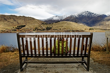 Young girl admires the view over Lake Hayes to the Remarkables, Queenstown, South Island, New Zealand