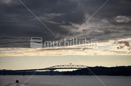 Storm clouds brewing at sunset above the Auckland Harbour Bridge (selective focus)