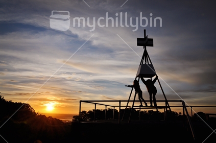 Mum and daughter climb the trig station on Mt Albert at sunset, Auckland