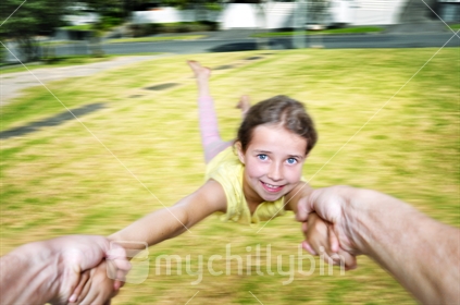 A young girl gets a helicopter ride from her dad (motion blur)