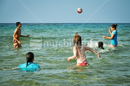 Kids play catch in the sea (selective focus)