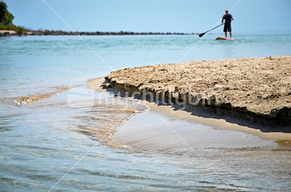 A paddle boarder enters an estuary mouth (selective focus) see also Image #100468_272