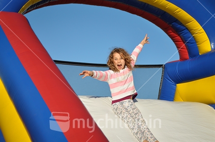 Happy girl on an inflatable slide
