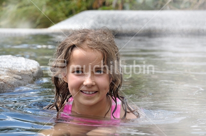 Girl relaxes in a thermal pool (selective focus and some motion blur)