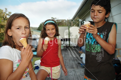 Kids eat ice creams on the deck (selective focus)