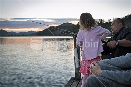 Young girl and her Uncle fish off a jetty