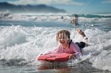 Happy girl on a boogie board (selective focus and some motion blur) 