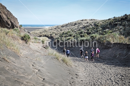 Family walking to Karekare Beach