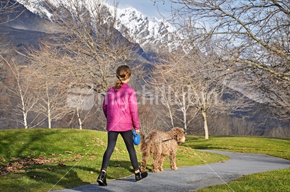 A girl walks a dog (selective focus and some motion blur)