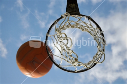 Netball going into a hoop from below (selective focus and motion blur)