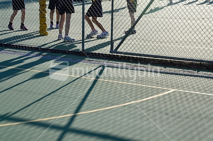 Long shadows cast on a netball court