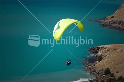A paraglider sails over Taylors Mistake, Banks Peninsula.