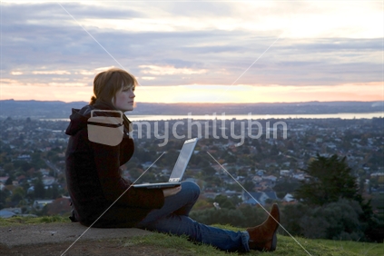 Young woman on hill with laptop (self employed, author, poet, ...)