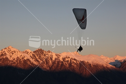 Paraglider silhouetted against the Remarkables at sunset, Queenstown.  Photo taken from Bob's Peak.